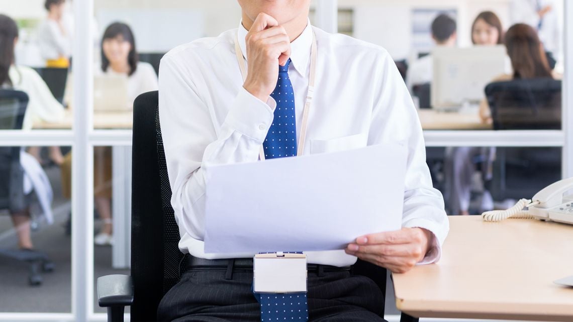 オフィスで思案げな男性の管理職のイメージ