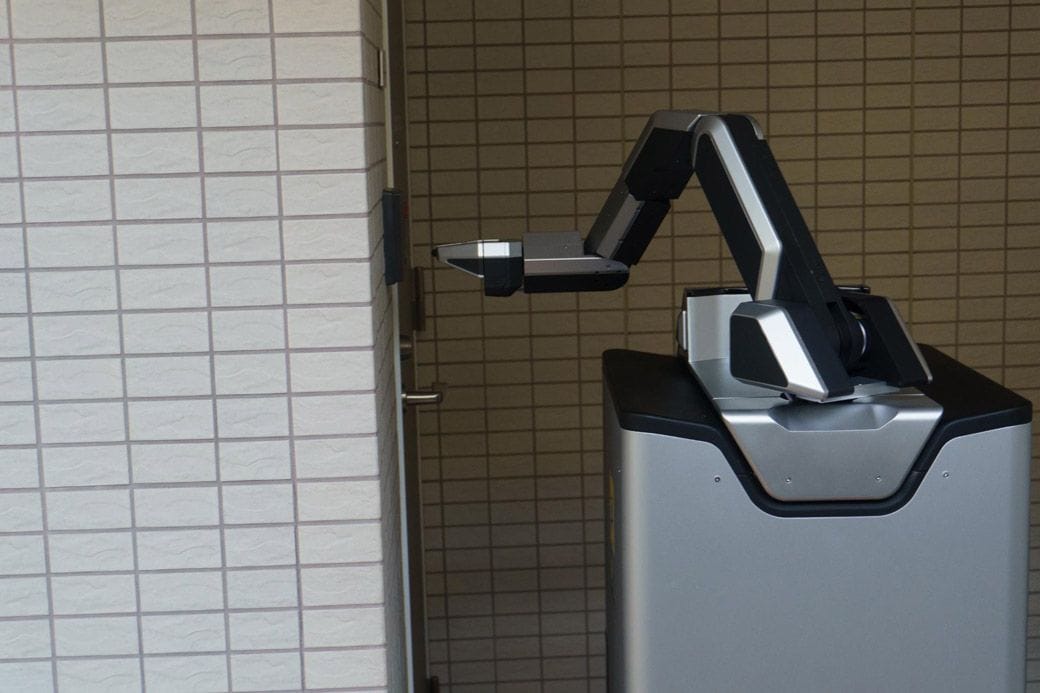 インターフォンを鳴らして待機するロボット