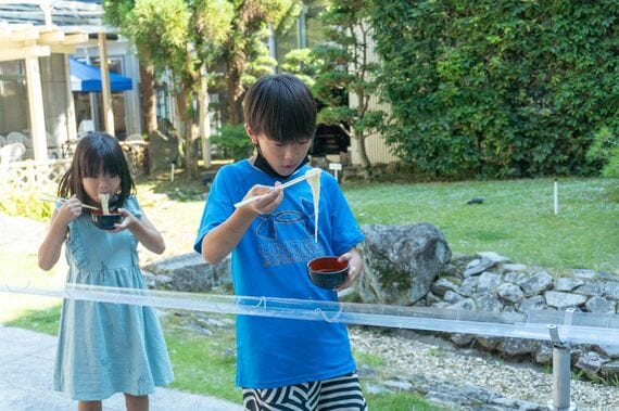 流しそうめんを食べる子ども