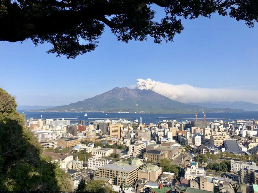 桜島と鹿児島市街地。錦江湾の間を桜島フェリーが日々運航（筆者撮影）