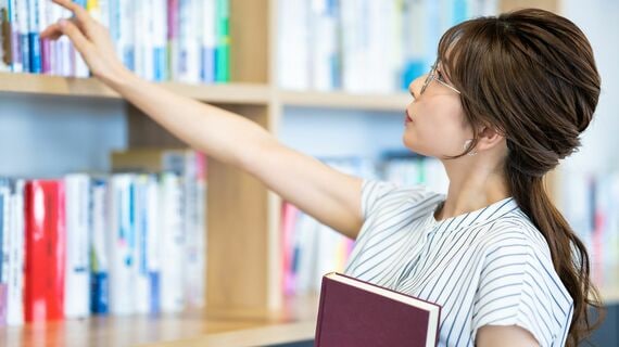 書棚を見る女性