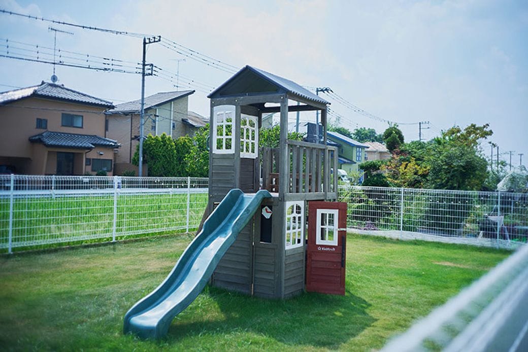 ぐるりとフェンスで囲んだ芝生の庭は、まるでドッグランのようで子どもも愛犬も思い切り走り回れます。木製の遊具は、体操を習うなど体を動かすのが大好きな長女に大好評（写真撮影：相馬ミナ）