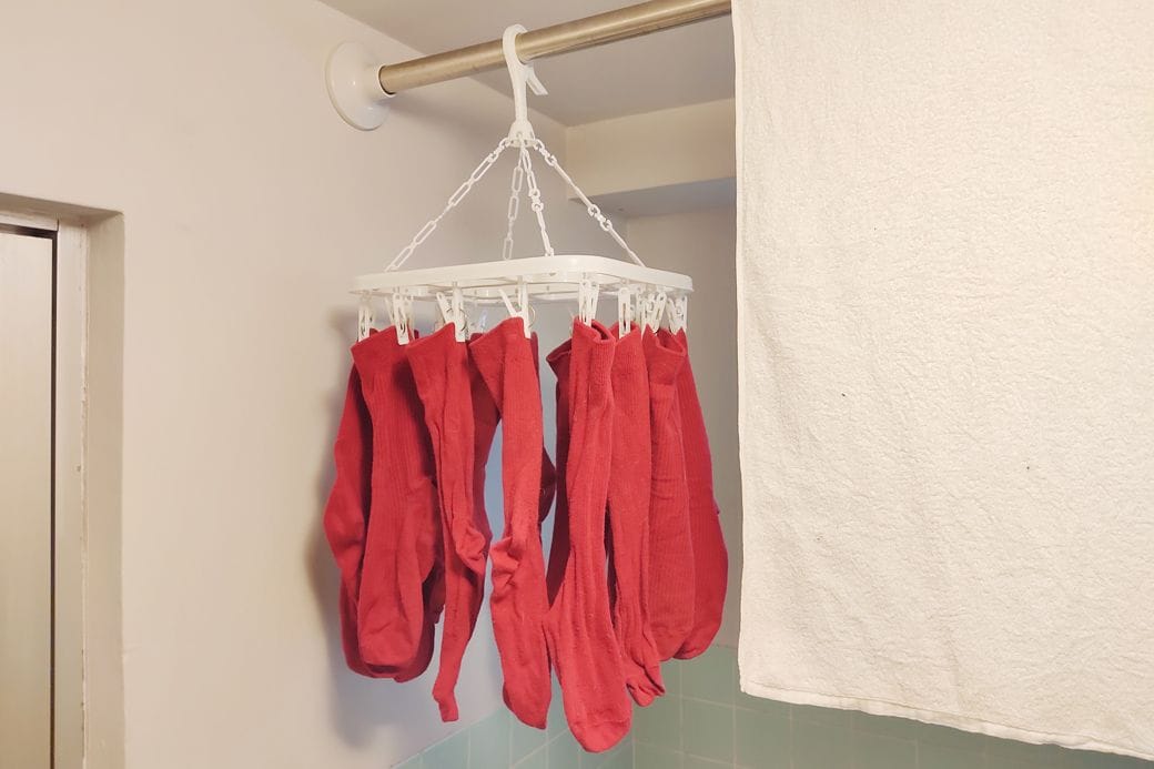 洗濯をサボりすぎると、ピンチハンガーにズラリと赤い靴下が並ぶことも（筆者撮影）