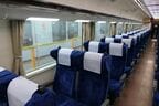 大型の側面窓と荷棚下に並ぶ照明