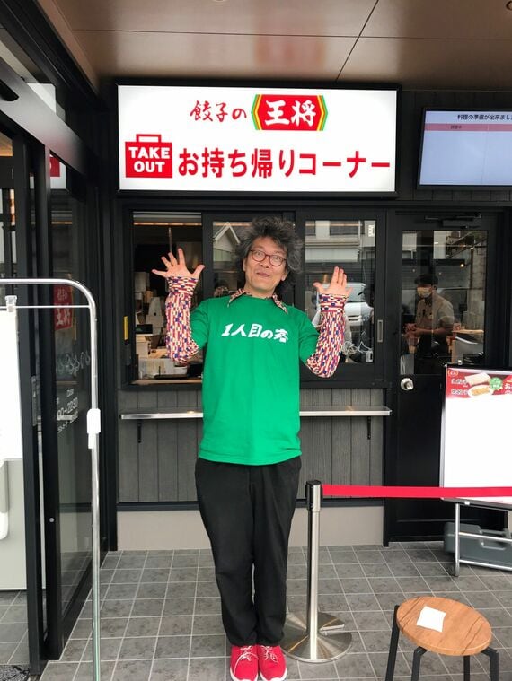 2024年5月30日、17時にオープンした「餃子の王将」金閣寺店の1人目の客になった涌井さん。後ろに並んでいた近所のおじさんが撮ってくれた写真(写真:涌井さん提供)