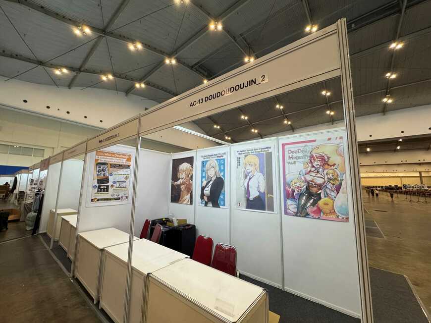 DouDouDoujin サークルスペース。企業・大手向けコーポレートブースの大型スペースを使用し、壁面には各先生の作品ポスターが貼られている（写真：水谷代表提供）