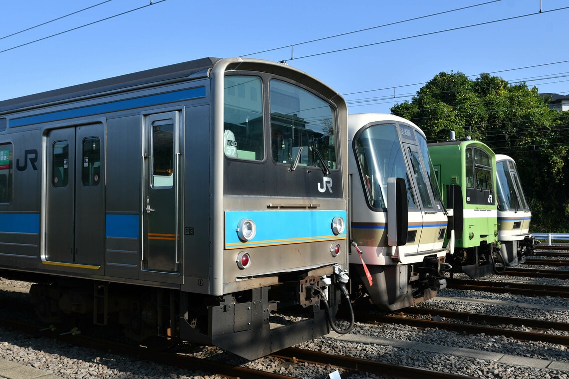 JR西日本が保有する205系の0番代（手前）。前面や乗務員扉にオレンジ色の細帯が入る（筆者撮影）