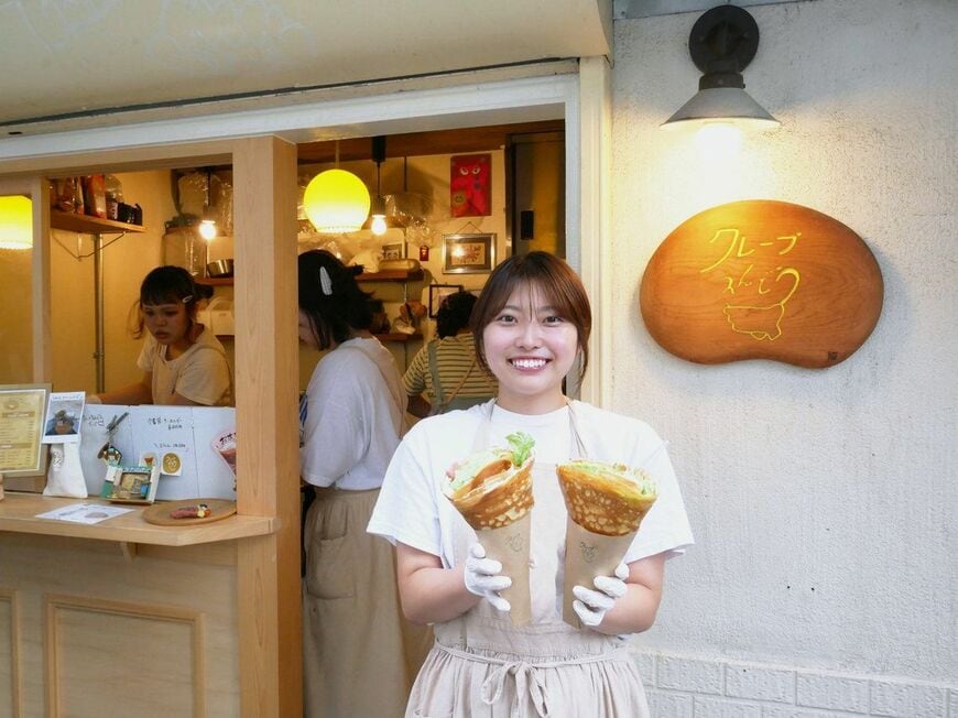 お店の前でクレープを持つ店主の遠藤桃華さん（写真：筆者撮影）