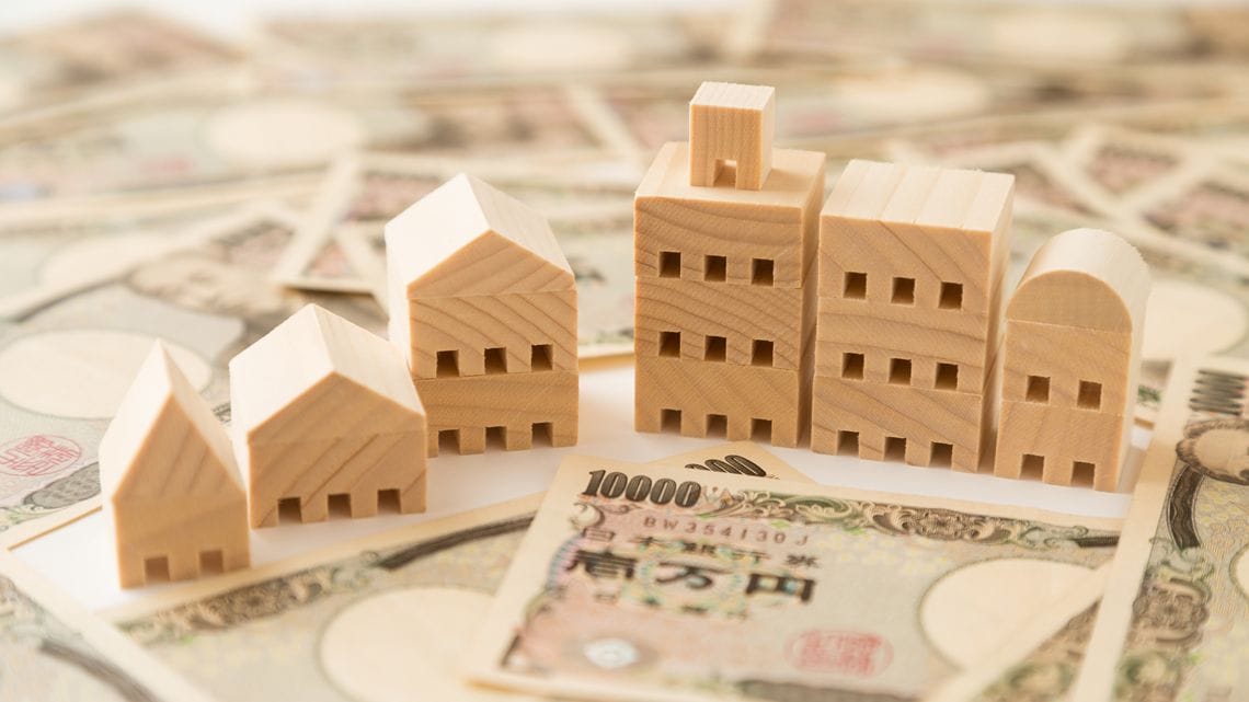 ビルや家などの模型と一万円札