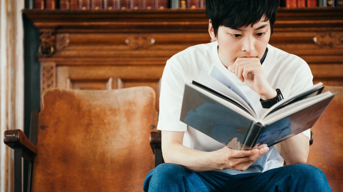 夢中になって本を読みふける男性
