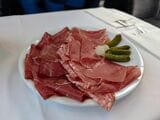 ルツェルン＝インターラーケン・エクスプレスのビストロカーで食べた生ハムとサラミ、ピクルスの盛り合わせ。山岳地帯が多いスイスは保存食の本場だ（写真：筆者撮影）