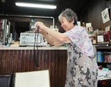 デジカメでお客さんを撮影する紀久恵さん（筆者撮影） 