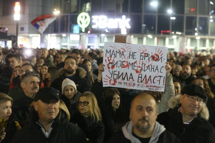 駅舎が崩落したノヴィサドの街で、担当大臣らの責任を問い抗議する人々。プラカードの訴えには簡体字も見える＝11月5日（写真：Filip Stevanovic/Anadolu via Getty Images）