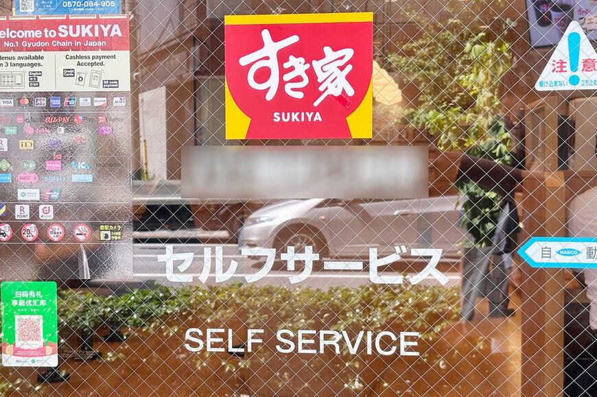 入り口自動ドアにセルフサービスの文字（筆者撮影）