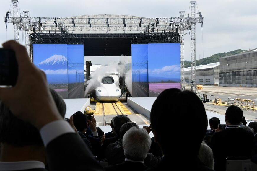 スモークの中から姿を現した台湾高速鉄路の新型車両N700ST。出荷セレモニーは派手な演出が行われた（記者撮影）