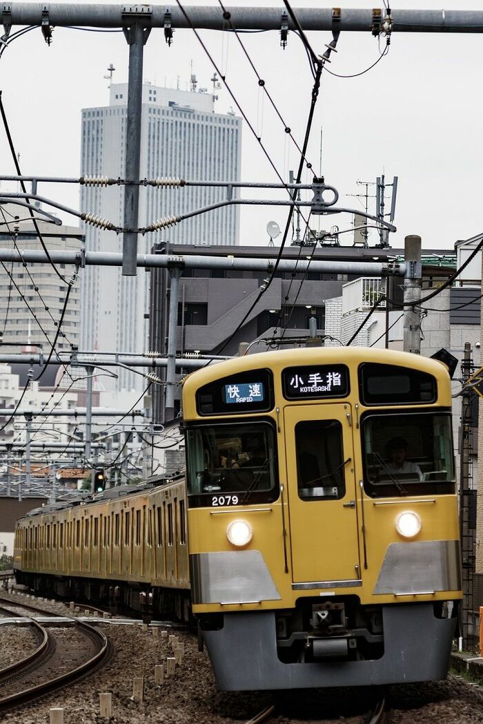 池袋の高層ビル群をバックに走る池袋線の電車