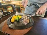 スタッフによってハンバーグが二つにカットされる（筆者撮影） 