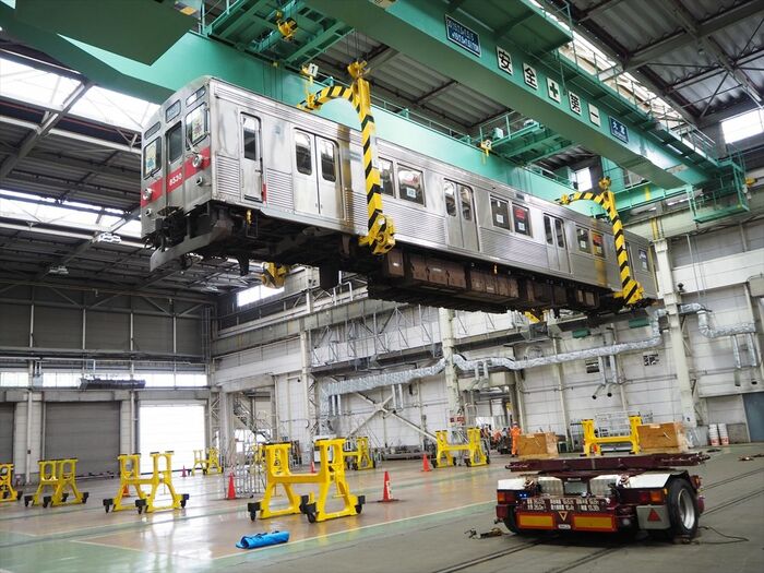 クレーンでゆっくりと吊り上げられる車体