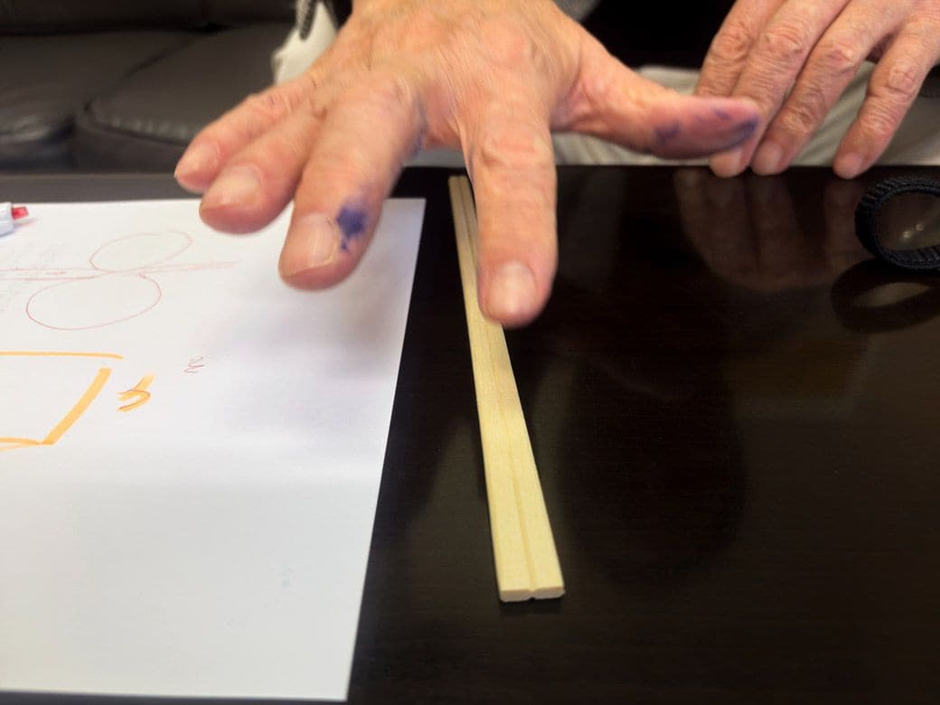 割り箸を転がしながら説明する澄川社長