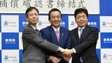 リニア工事の水資源問題に関する合意文書に署名した後、握手を交わす（左から）JR東海の丹羽俊介社長、静岡県の鈴木康友知事、国土交通省の水嶋智事務次官（記者撮影）