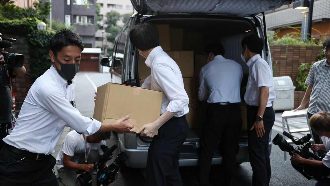 8月5日、東京都千代田区にある日本風力開発の塚脇正幸社長宅の家宅捜索に入り、段ボールを運び出す東京地検の係官ら（写真：時事）