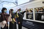 全線再開1番列車に手を振る児平駅長ら