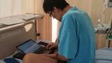 ベッドで仕事をする夫