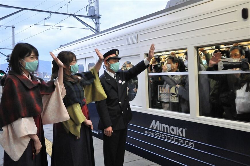 全線再開1番列車に手を振る児平駅長ら（記者撮影）