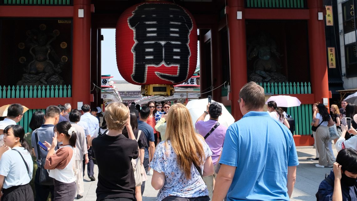 浅草寺の雷門の前で写真を撮る訪日観光客