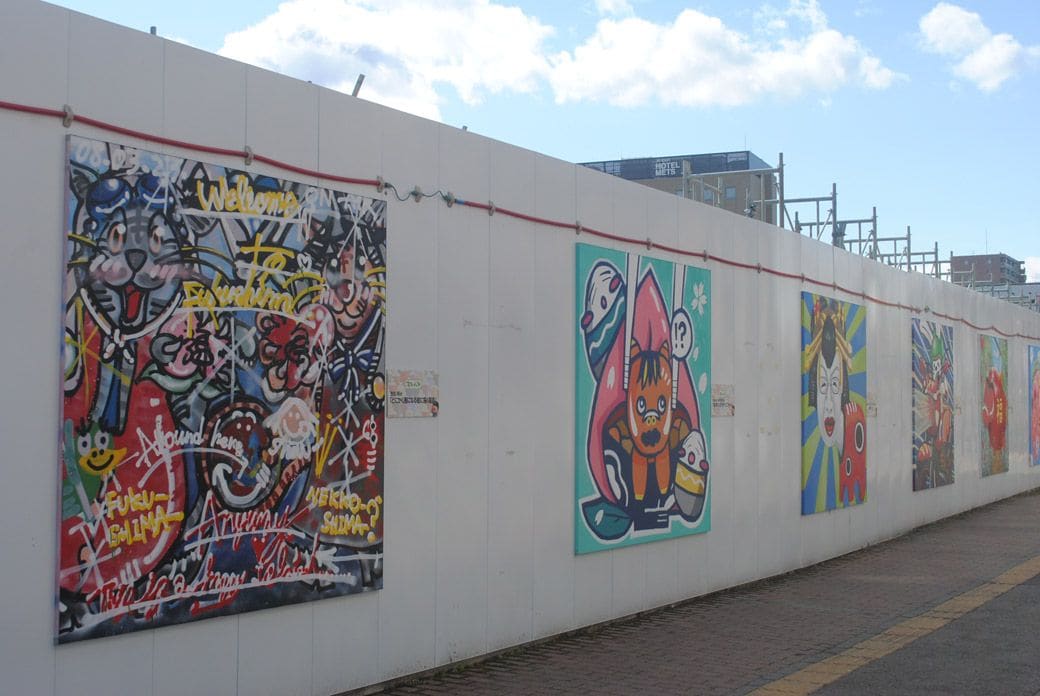 白い仮囲いの壁にはスプレーアートが展示されている