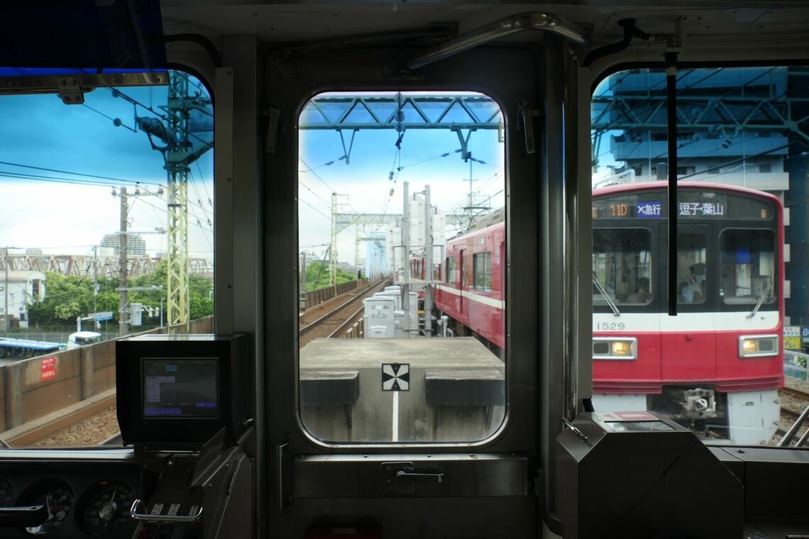 横を下り電車が通り抜ける（記者撮影）