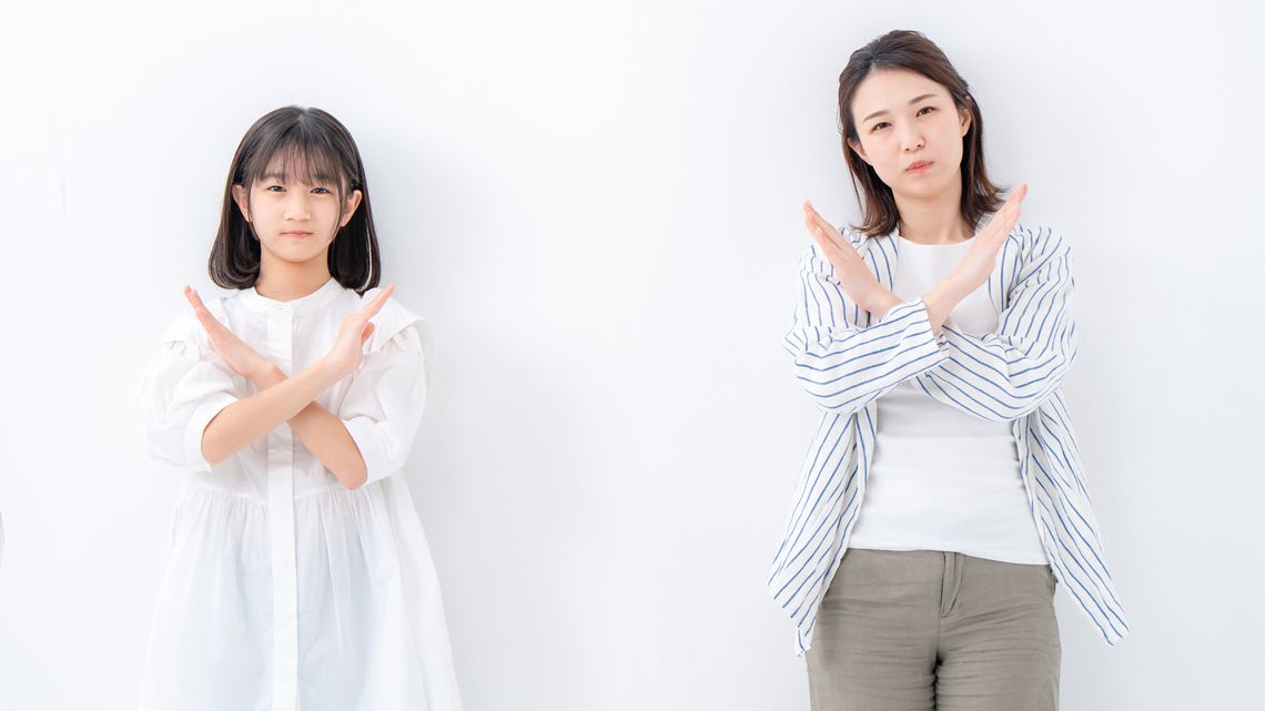 腕を交差してばつ印を作る親子