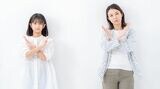 腕を交差してばつ印を作る親子