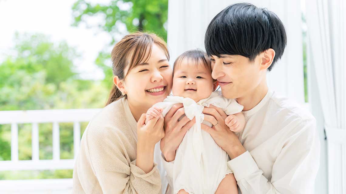 笑顔の赤ちゃんと両親 子育てイメージ