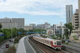 千里中央駅南側の地上を走る北大阪急行の電車（記者撮影）