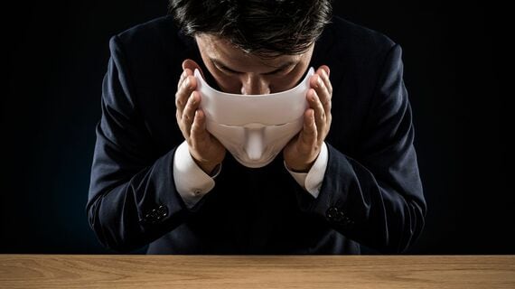 仮面を外す男性のイメージ