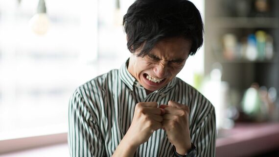 つらい表情をする若い男性のイメージ