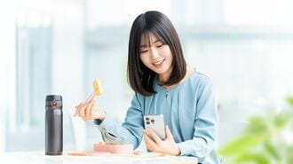 食事をしながらスマホを見る女性