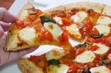 ナポリの窯の、ナポリのマルゲリータ Mサイズ ナポリ生地（1830円）。ボリュームよりもチーズの食感と香ばしさに特化したピザに思える。ここに追加して生ハムやモッツァレラチーズを乗せて食べてもおいしそうだ（筆者撮影）
