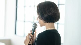 喪服でマイクを持つ女性