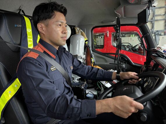 EV消防ポンプ車の運転席に座る隊員（筆者撮影）