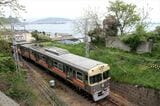 瀬戸内海をバックに走る伊予鉄道3000系。当初は写真の塗装だったが現在は「伊予鉄カラー」のオレンジ1色になった（撮影：南正時）