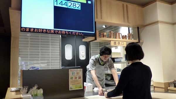 モニターで商品の出来上がりを確認し、商品を受け取る