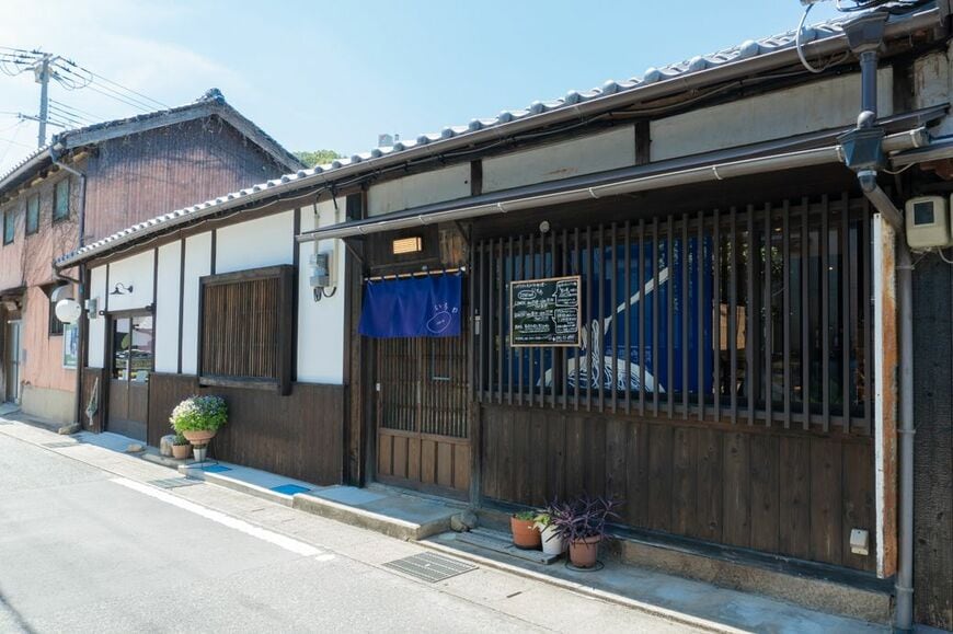 築100年を超える町家をリノベーションした店舗は、歴史を感じる落ち着いた雰囲気だ。格子戸にかけられた紺色の暖簾からは軽やかさが感じられる（筆者撮影）