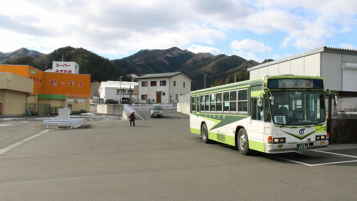 スーパーの敷地内にある上平田バス停に到着した岩手県交通の上大畑行き（筆者撮影）
