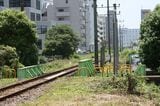 ローカル線のような単線非電化の線路が高層建築に囲まれて延びている（筆者撮影）