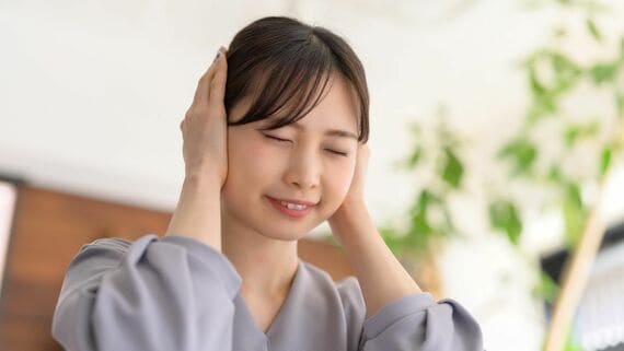 耳をふさぐ女性