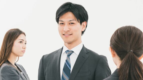 二人の男性の間に立つスーツ姿の男性