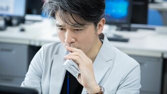 栄養補給ゼリーを飲みながら仕事に打ち込む人物