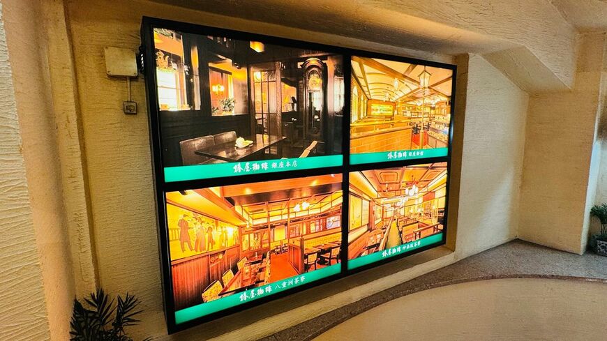 階段を上がる途中には、椿屋珈琲グループ各店の店内写真が並ぶ。外の喧騒から店内へ、気分が切り替わっていく（写真：筆者撮影）